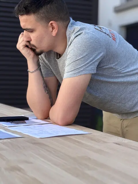 Hugo Di Murro étudiant les plans techniques avant fabrication — atelier HDM Menuiserie Givors