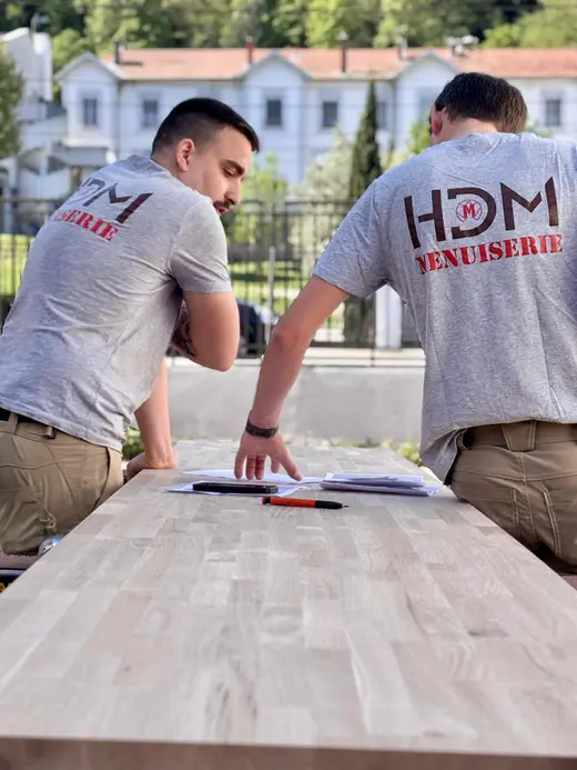 L'équipe HDM Menuiserie portant les t-shirts logo HDM MENUISERIE sur un chantier