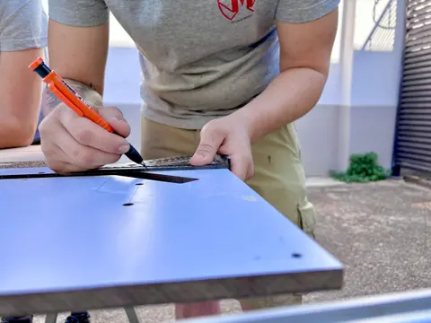 Traçage à l'équerre et au stylo orange sur plaque MDF — atelier HDM Menuiserie Givors